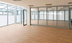 Large office with wooden flooring and a glass partitioning wall